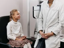 A young child undergoing a pediatric eye examination with picture-card vision testing
