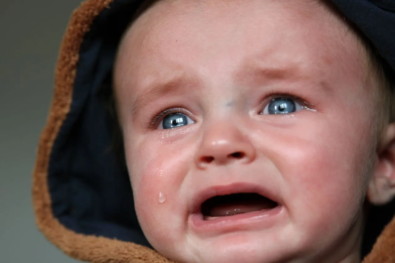 Infant with a watery eye from a blocked tear duct