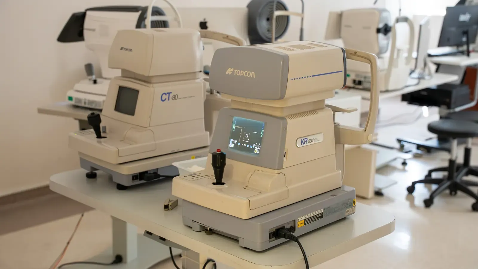 Two ophthalmic diagnostic units on a bench in a bright measurement room.