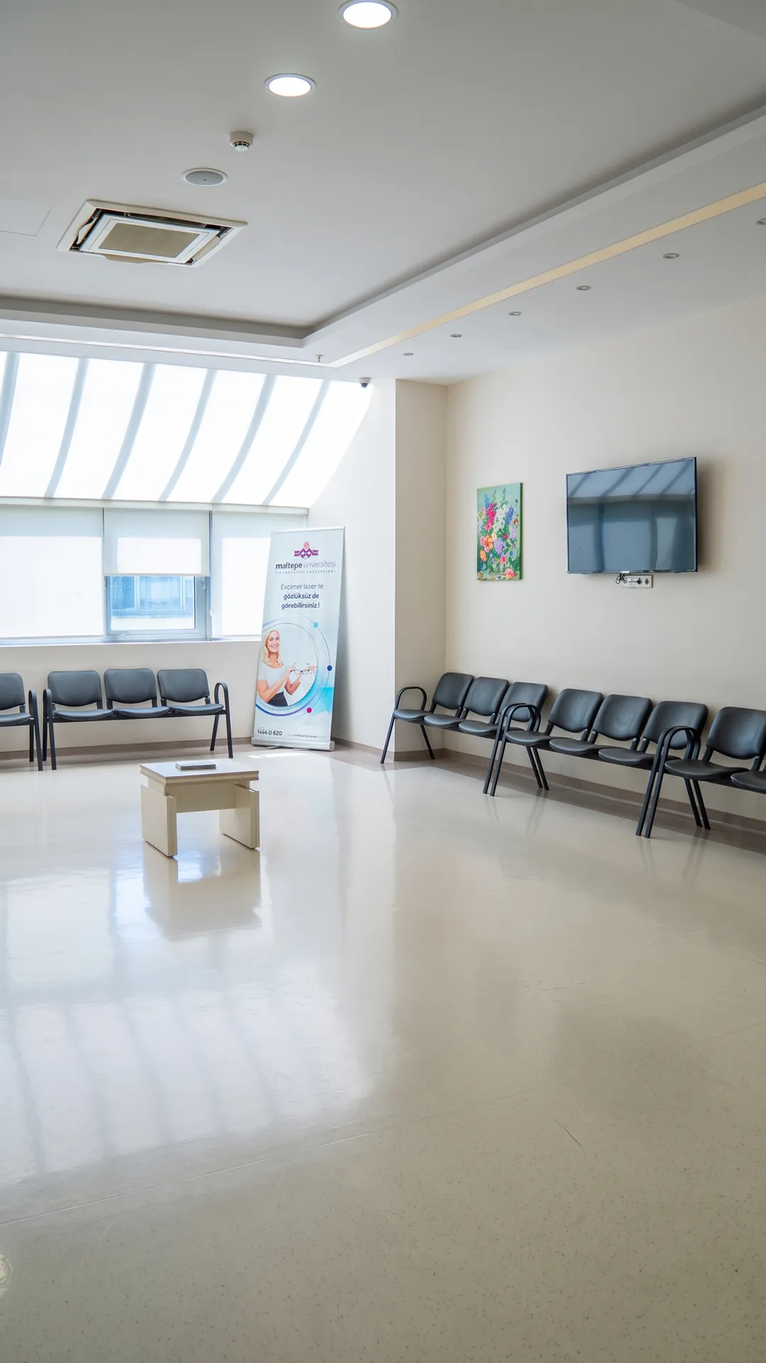 The daylit waiting area at the İstanbul clinic, with rows of seating along a tall window wall.